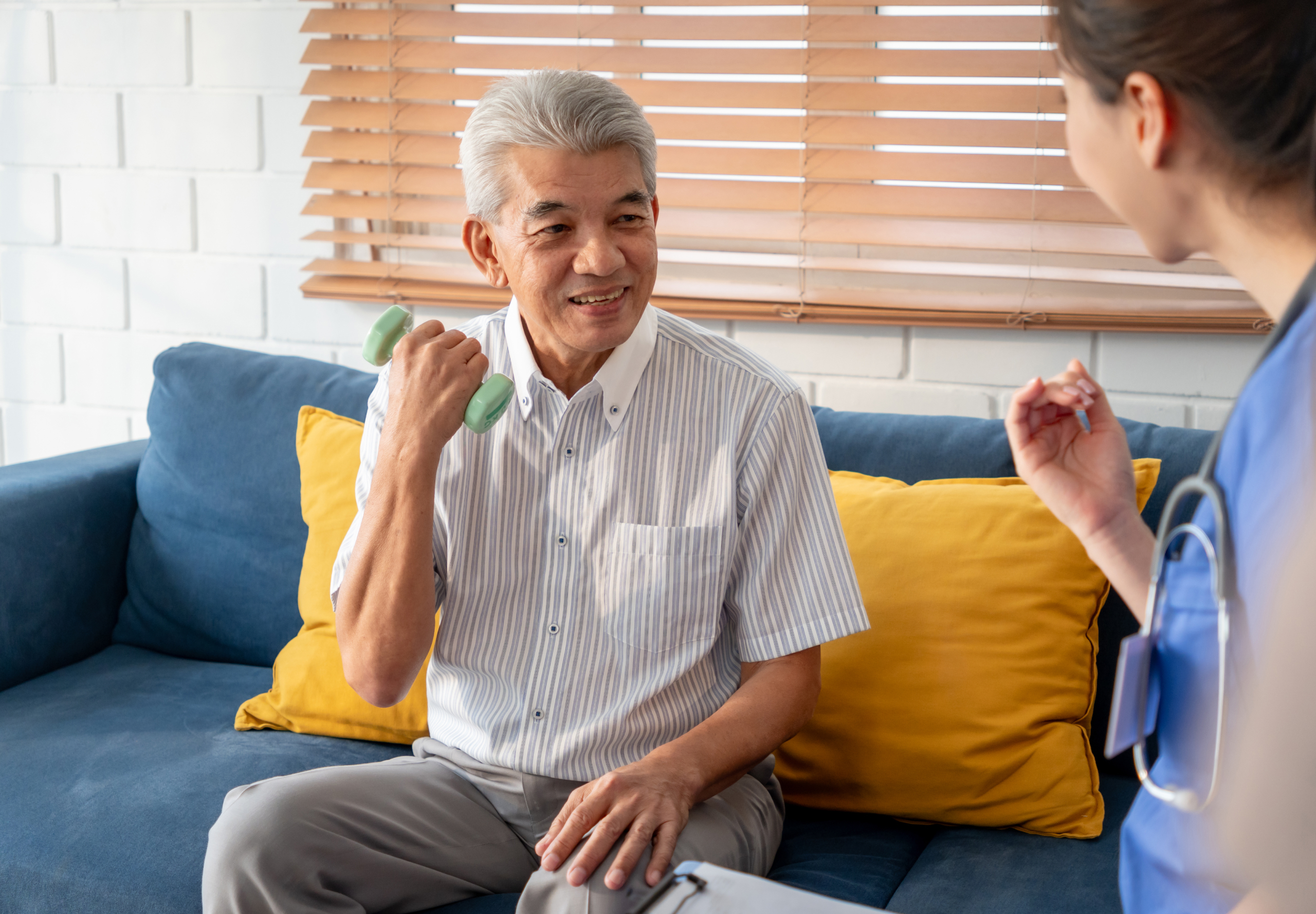 Elderly man with healthcare worker in physiotherapy session